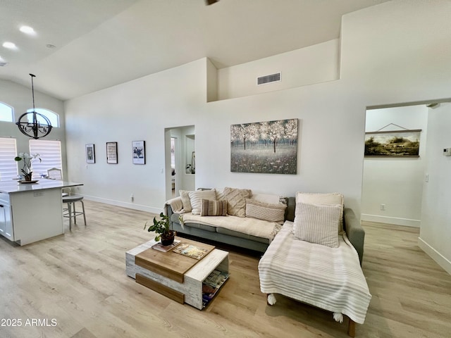 4925 W Bluefield Ave, Glendale, AZ 85308 - living room with high vaulted ceiling, light wood-type flooring, and a chandelier