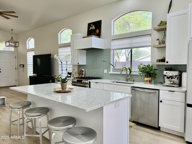 4925 W Bluefield Ave, Glendale, AZ 85308 - kitchen with appliances with stainless steel finishes, open shelves, light wood-type flooring, white cabinets, and lofted ceiling