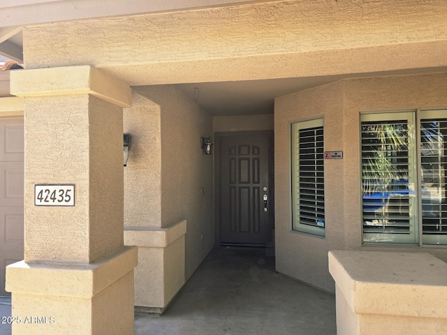 entrance to property featuring stucco siding