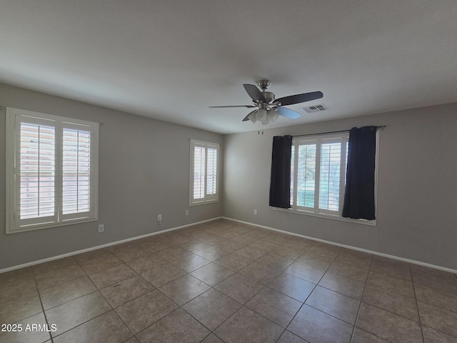 unfurnished room featuring tile patterned floors, baseboards, a ceiling fan, and visible vents