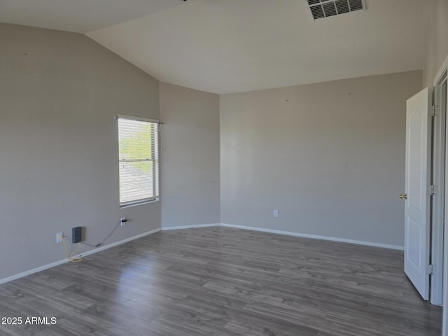 empty room with baseboards, visible vents, wood finished floors, and lofted ceiling