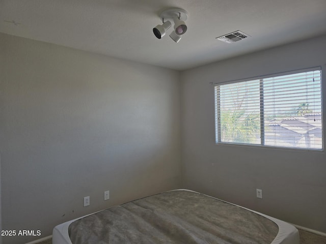 carpeted spare room featuring visible vents