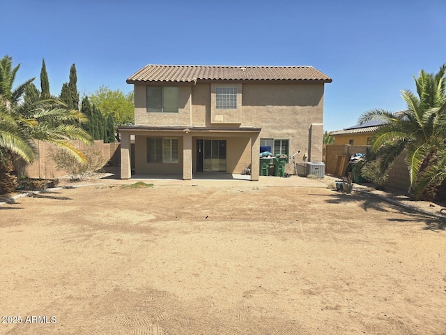 rear view of property with central air condition unit, a fenced backyard, a patio area, and stucco siding