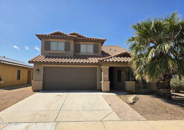 mediterranean / spanish-style house featuring a tiled roof, a garage, driveway, and stucco siding
