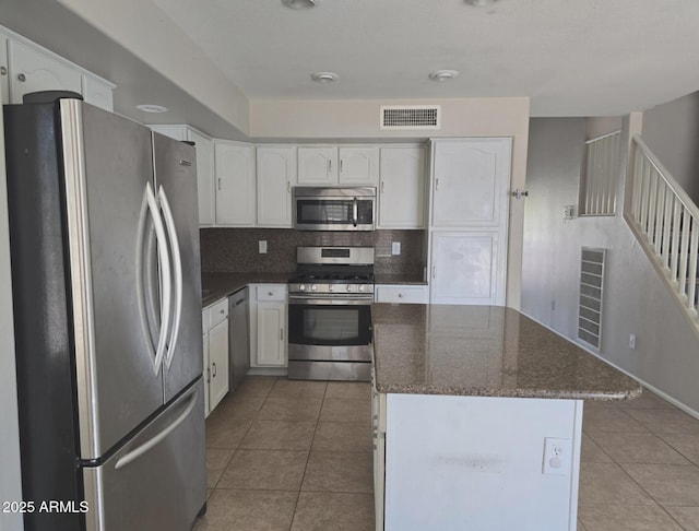 kitchen with visible vents, white cabinets, light tile patterned flooring, and stainless steel appliances