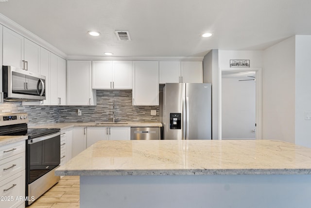 2706 W Isabella Ave, Mesa, AZ 85202 - kitchen featuring stainless steel appliances, decorative backsplash, white cabinets, light wood finished floors, and recessed lighting