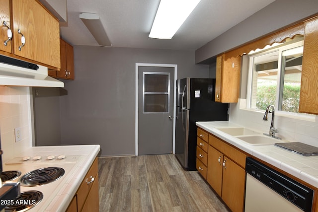 5720 E University Dr, Mesa, AZ 85205 - kitchen with white dishwasher, a sink, backsplash, light wood-type flooring, and tile countertops