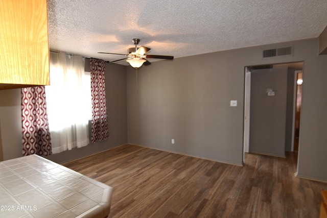 5720 E University Dr, Mesa, AZ 85205 - unfurnished bedroom featuring wood finished floors, a textured ceiling, and ceiling fan