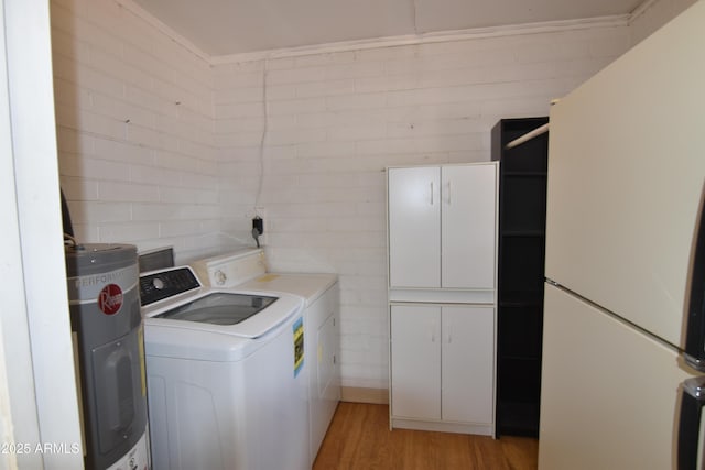 5720 E University Dr, Mesa, AZ 85205 - laundry area with electric water heater, cabinet space, washing machine and clothes dryer, and light wood-style flooring