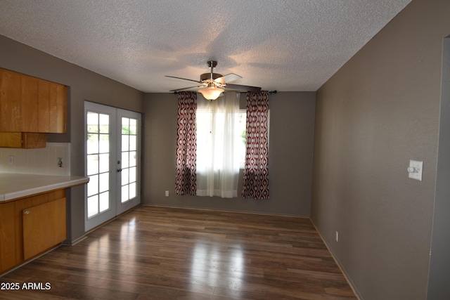 5720 E University Dr, Mesa, AZ 85205 - unfurnished dining area featuring french doors, dark wood finished floors, a textured ceiling, a ceiling fan, and baseboards
