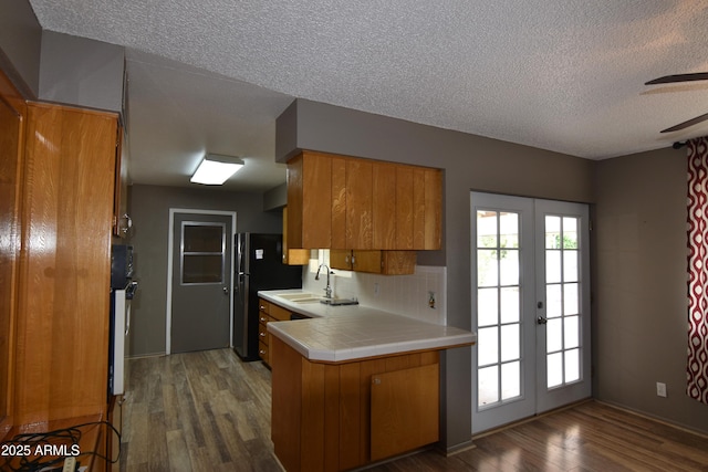 5720 E University Dr, Mesa, AZ 85205 - kitchen with brown cabinets, a sink, french doors, dark wood-style flooring, and a textured ceiling