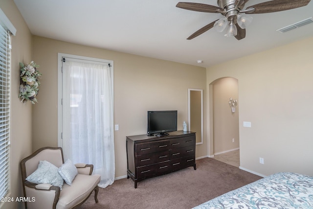 26404 W Zachary Dr, Buckeye, AZ 85396 - bedroom with arched walkways, baseboards, visible vents, light colored carpet, and a ceiling fan