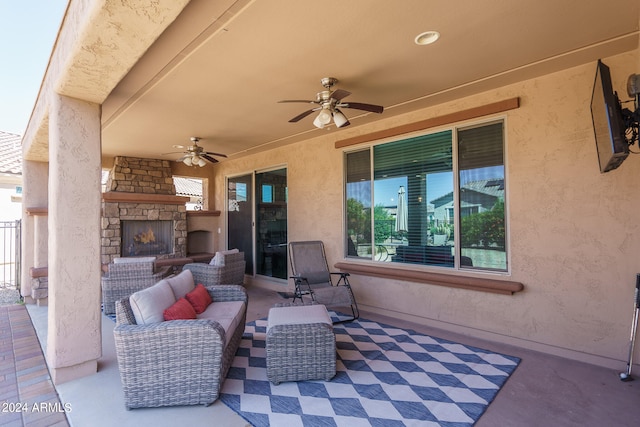 view of patio / terrace with an outdoor living space with a fireplace and ceiling fan