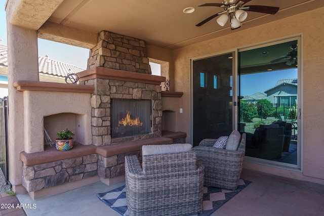 view of patio with ceiling fan and an outdoor stone fireplace