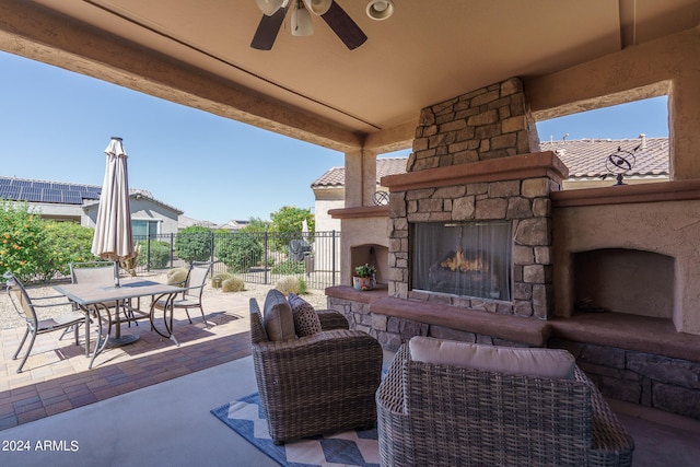 view of patio / terrace with ceiling fan and an outdoor stone fireplace