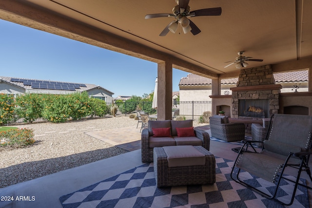 view of patio with ceiling fan and an outdoor living space with a fireplace