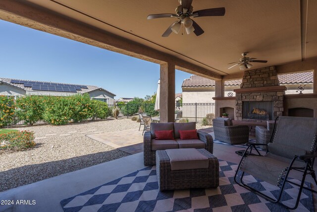 26404 W Zachary Dr, Buckeye, AZ 85396 - view of patio / terrace with an outdoor living space with a fireplace, a ceiling fan, and a fenced backyard