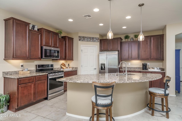 26404 W Zachary Dr, Buckeye, AZ 85396 - kitchen featuring a kitchen breakfast bar, a sink, a kitchen island with sink, appliances with stainless steel finishes, and visible vents
