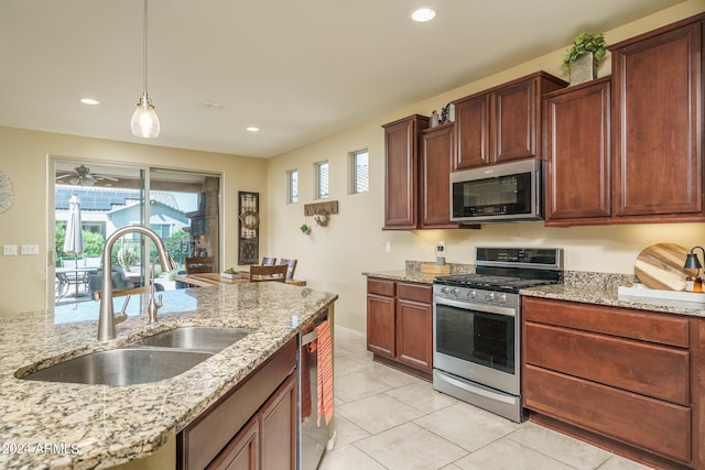26404 W Zachary Dr, Buckeye, AZ 85396 - kitchen featuring stainless steel appliances, a sink, recessed lighting, pendant lighting, and light stone countertops