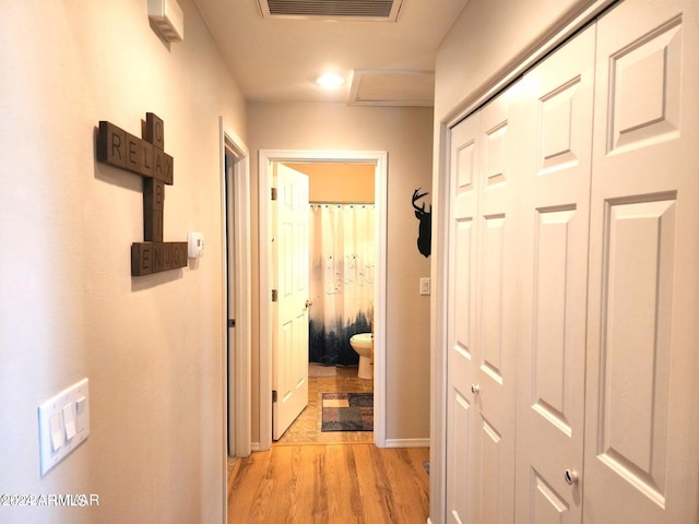 hallway with light hardwood / wood-style floors