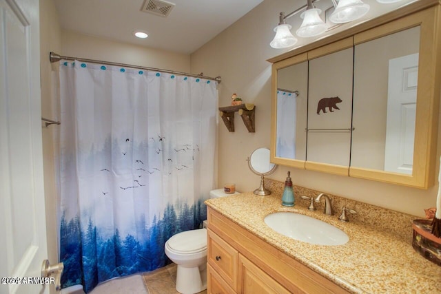 bathroom featuring tile patterned floors, toilet, vanity, and curtained shower