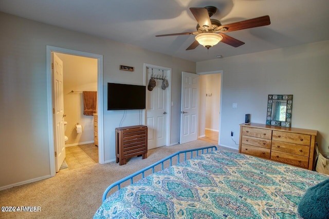 bedroom with ceiling fan, light carpet, and ensuite bathroom