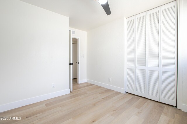 unfurnished bedroom with light hardwood / wood-style floors, a closet, and ceiling fan