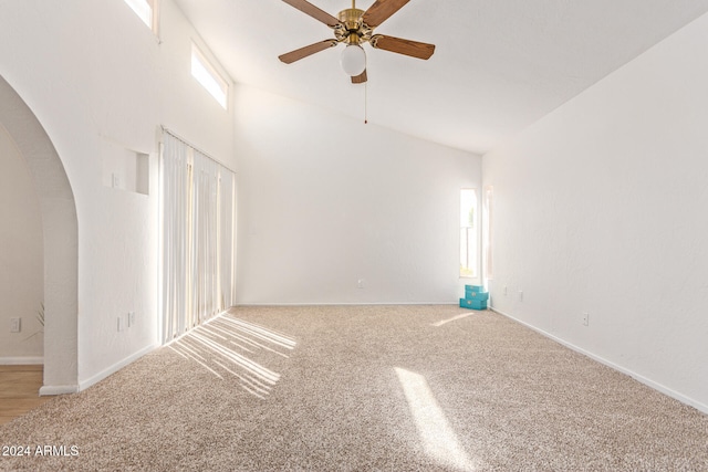 carpeted spare room featuring high vaulted ceiling and ceiling fan