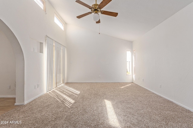 carpeted empty room featuring ceiling fan and high vaulted ceiling