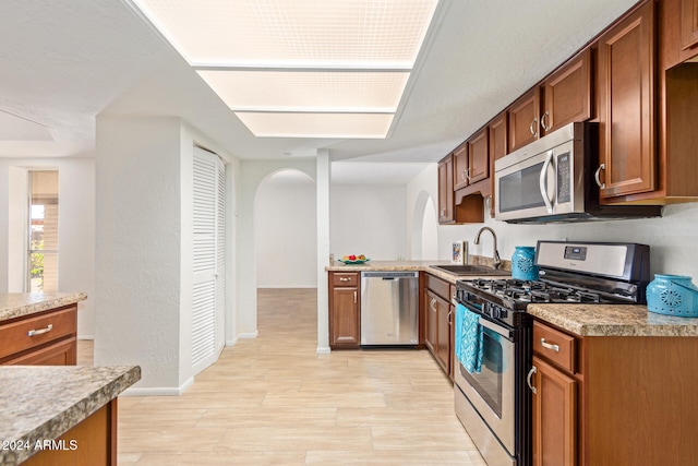 kitchen featuring appliances with stainless steel finishes, sink, and light hardwood / wood-style floors