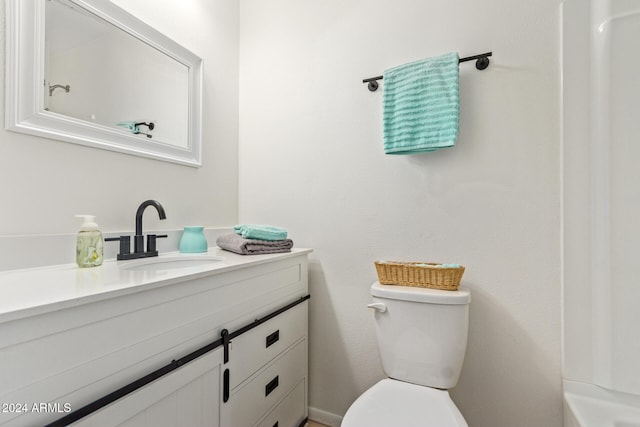 bathroom featuring vanity, toilet, and a shower