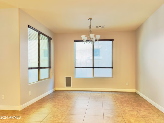 unfurnished room with light tile patterned floors and an inviting chandelier