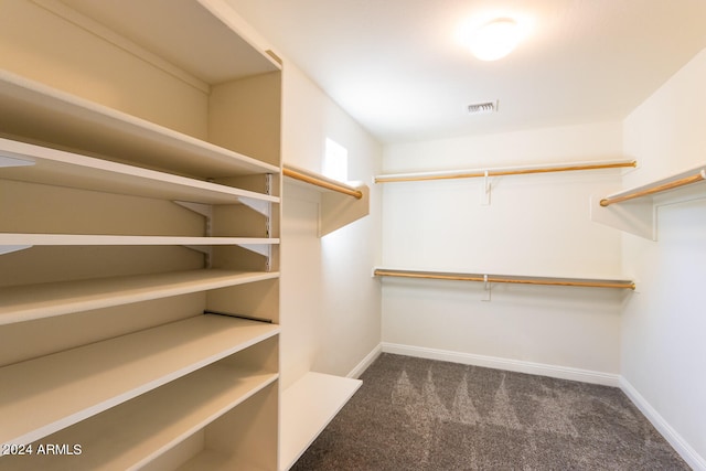 spacious closet featuring dark carpet