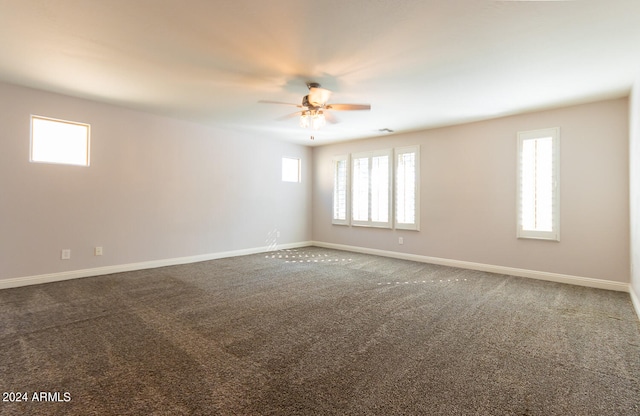 carpeted empty room with a healthy amount of sunlight and ceiling fan