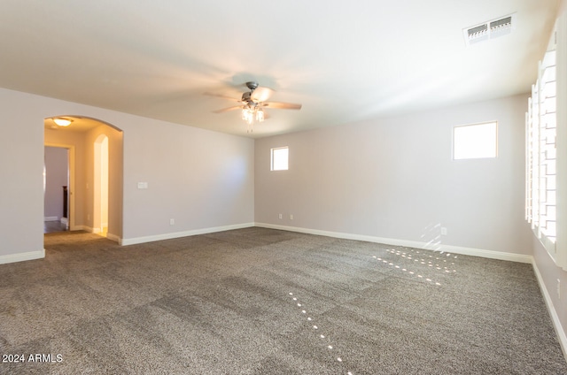 carpeted empty room with a healthy amount of sunlight and ceiling fan