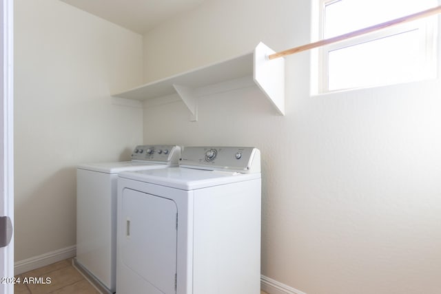 laundry area with washing machine and clothes dryer and light tile patterned floors