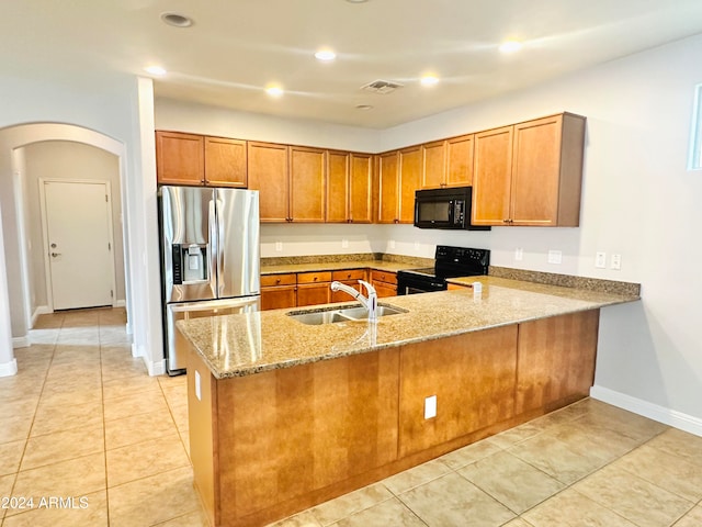 kitchen with kitchen peninsula, sink, black appliances, light tile patterned floors, and light stone counters