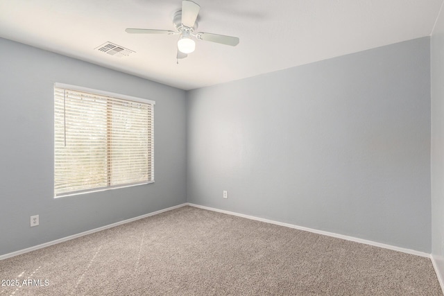 carpeted empty room featuring baseboards, visible vents, and a ceiling fan