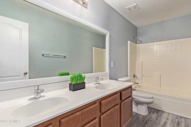 full bathroom with toilet, tub / shower combination, a sink, and visible vents