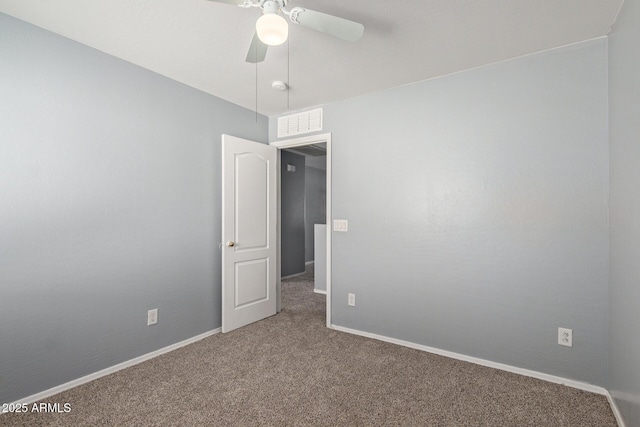 carpeted spare room with ceiling fan, visible vents, and baseboards