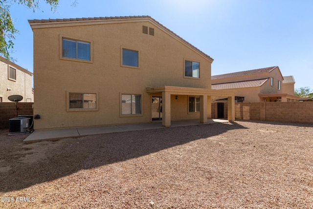 rear view of house featuring a patio, central AC unit, fence, and stucco siding