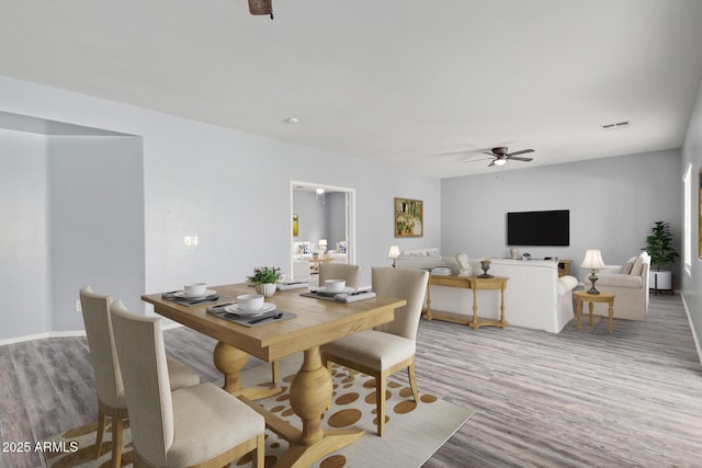 dining room featuring a ceiling fan, visible vents, and wood finished floors