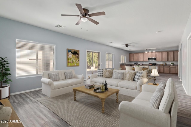 living area featuring light wood-style floors, plenty of natural light, and visible vents