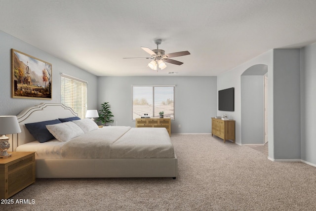 bedroom featuring arched walkways, visible vents, carpet flooring, ceiling fan, and baseboards