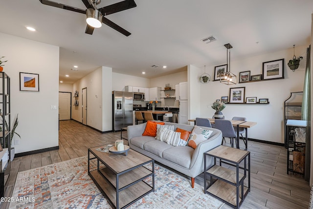 living room with light wood-style flooring, visible vents, recessed lighting, and a ceiling fan