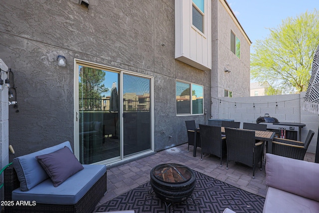view of patio / terrace with an outdoor fire pit, outdoor dining area, and fence