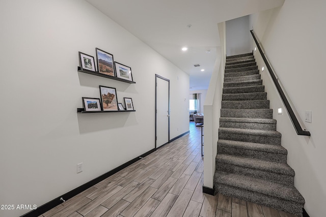 stairs featuring wood tiled floor, recessed lighting, and baseboards