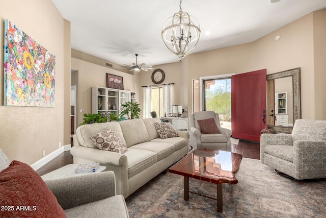 living room featuring baseboards, ceiling fan with notable chandelier, and visible vents