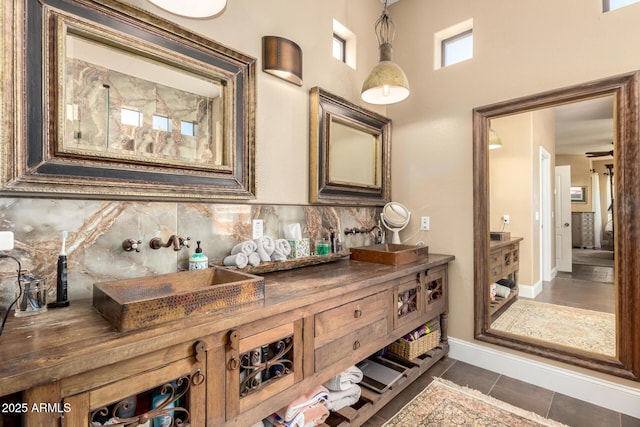 bathroom with backsplash, baseboards, and tile patterned flooring