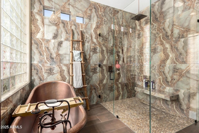 full bath with a marble finish shower and a soaking tub